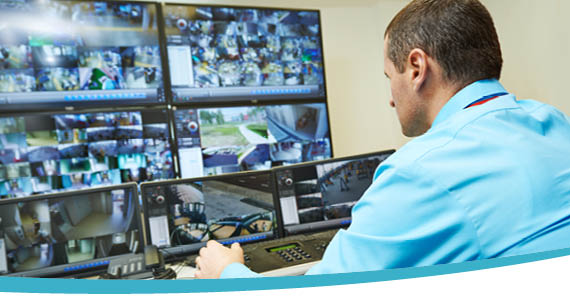 Operator watching a wall of CCTV monitors