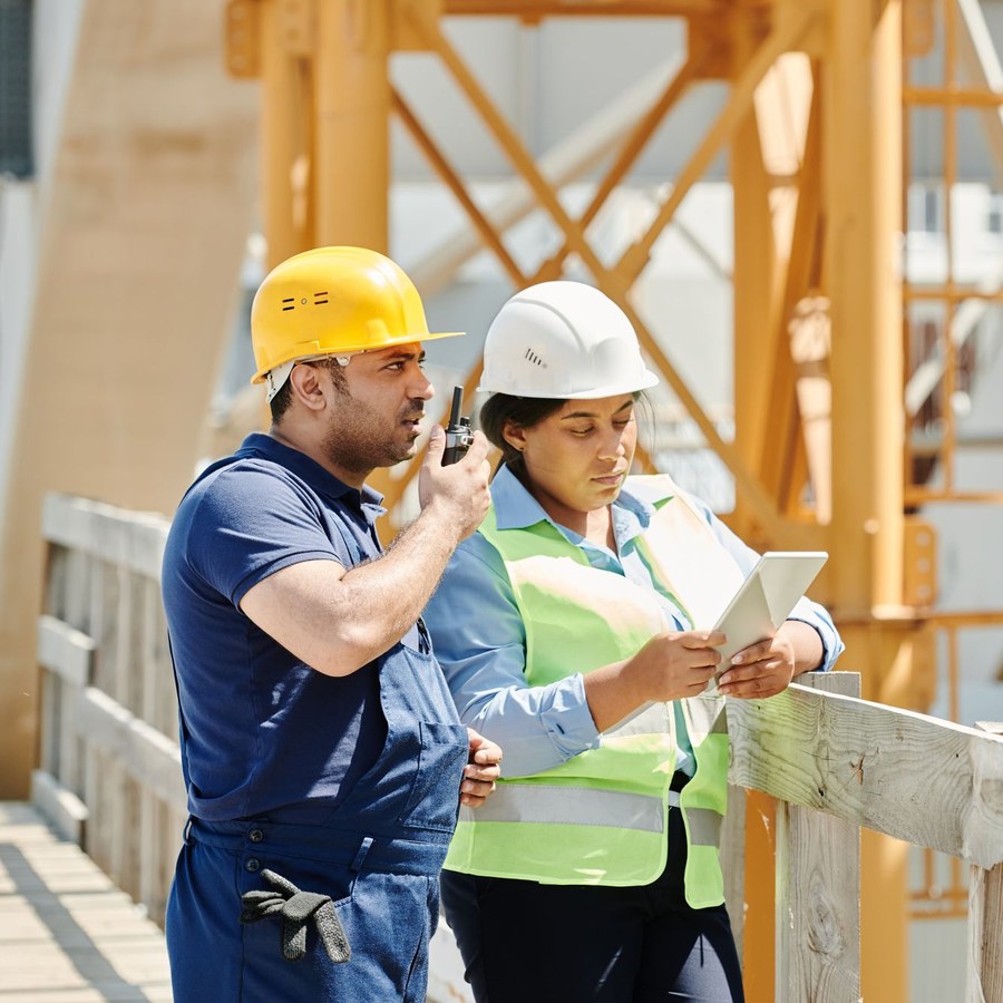 Construction workers on site, one using a two-way radio