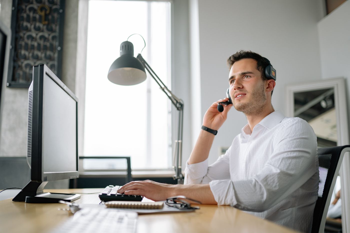 Man on a headset at an office desk