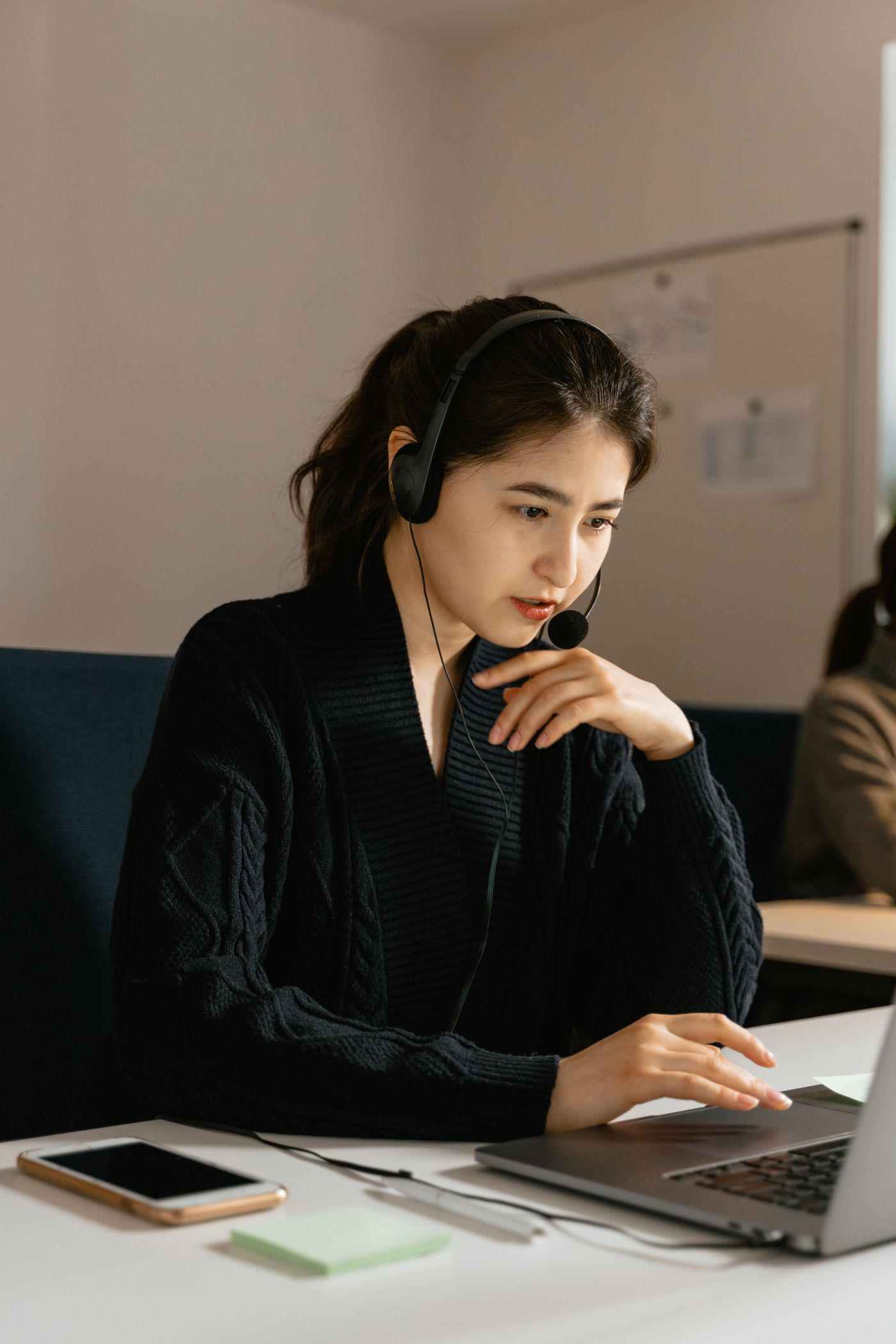 Woman on a headset working at a laptop